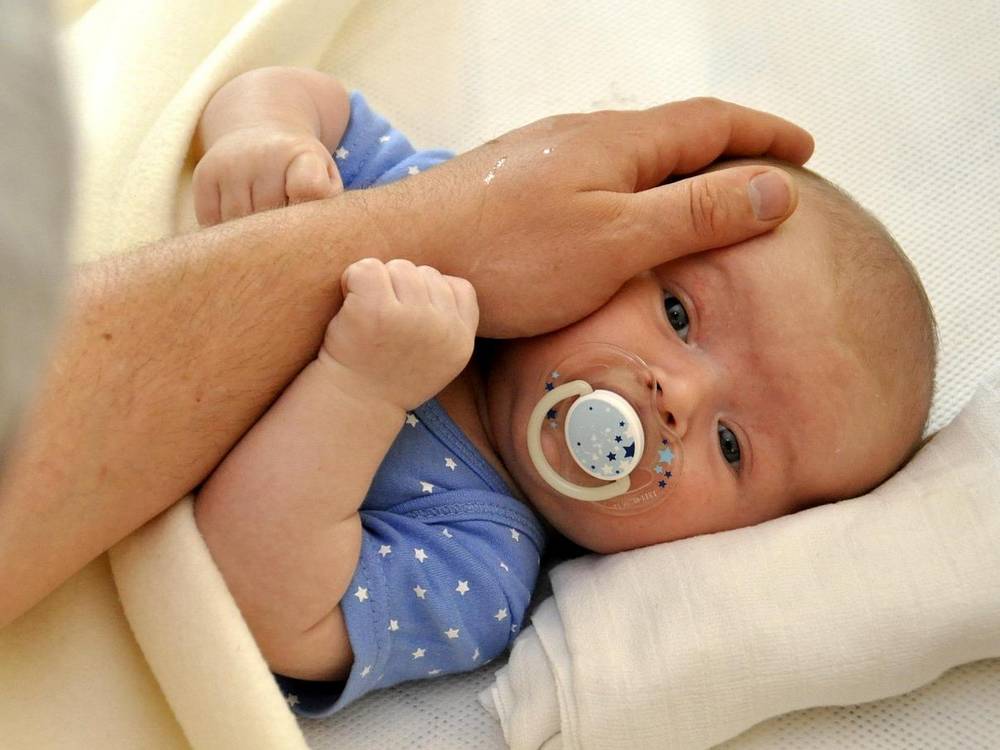 Dojenčka z dudo boža odrasla roka