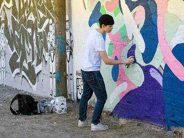 Mladenič riše grafite