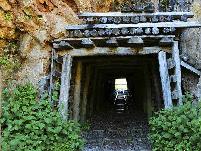 Zapuščen rudniški rov z železniškim tirom